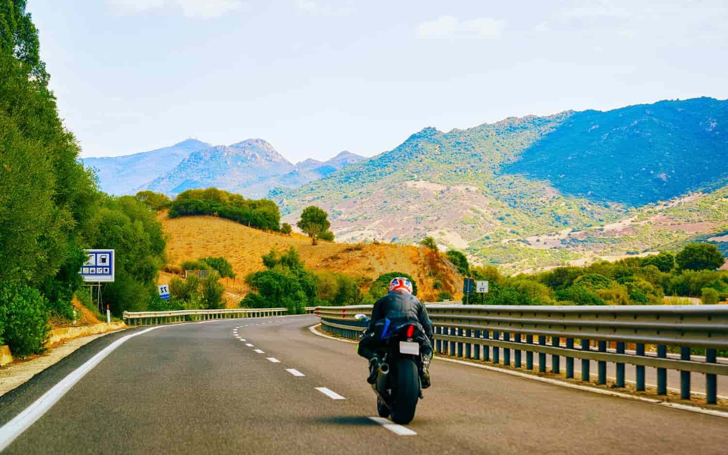 Motocicleta recorriendo una pintoresca carretera europea en una aventura en moto por Europa