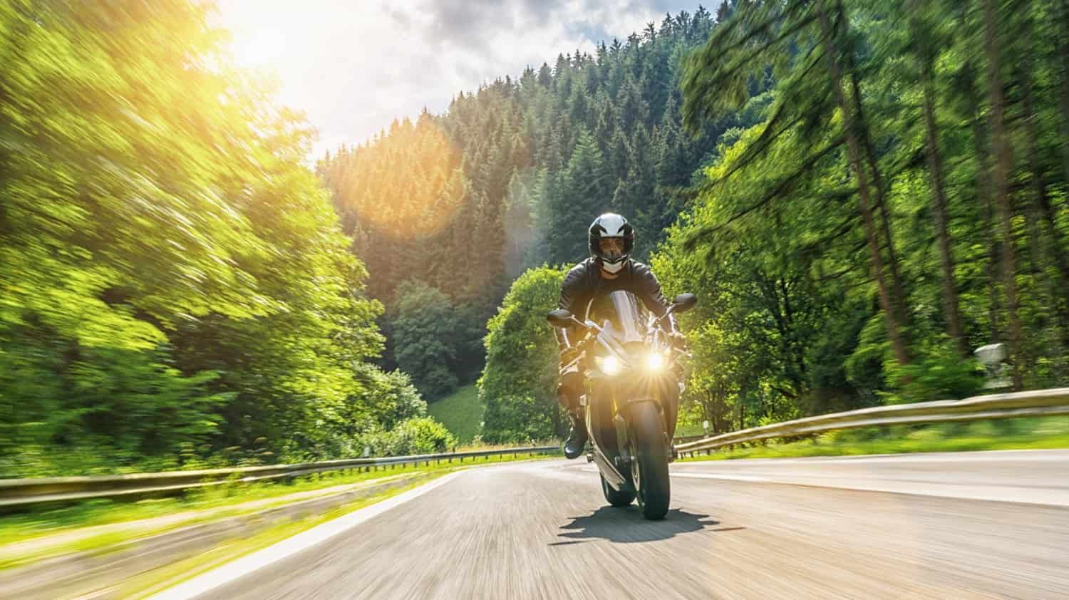Motociclista disfrutando de una ruta ecológica rodeado de paisajes impresionantes